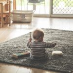 リビングで一人夢中でおもちゃで遊ぶ赤ちゃん