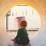 1人で大きな穴に入って遊ぶ幼児