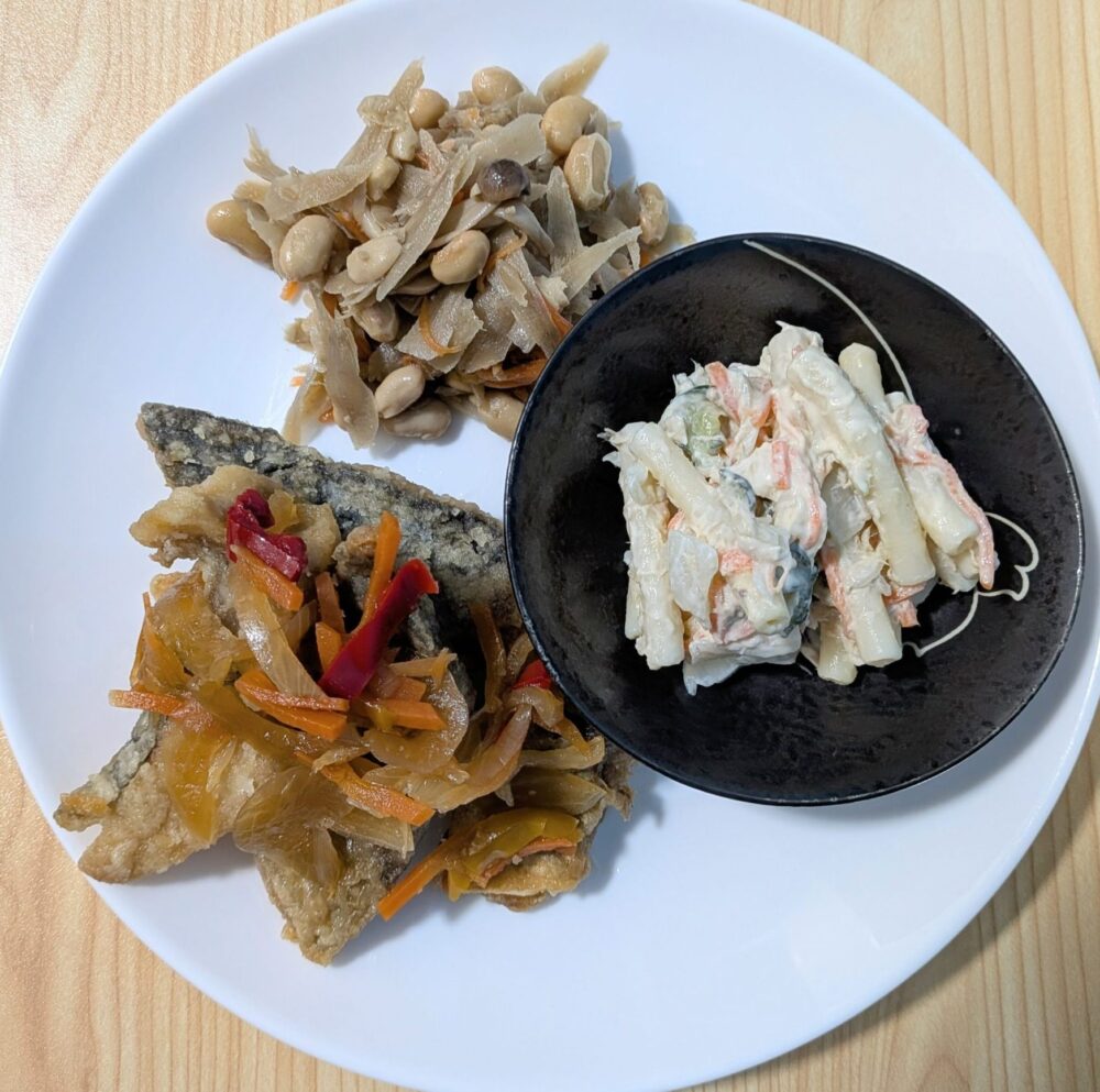 1人分の白いお皿の上に、アジの唐揚げ南蛮だれがけと、マカロニサラダ、ごぼうと大豆の炒め煮の3品を上から撮影。鮮やかな色合いがお皿に並んでいる。