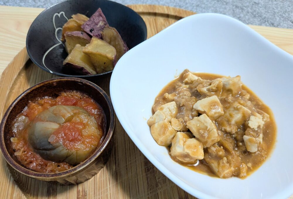 木のお皿の上に、主菜の辛くない麻婆豆腐と、副菜のさつまいもの甘露煮、茄子とズッキーニのラタトゥイユがおいしそうに並んでいる。