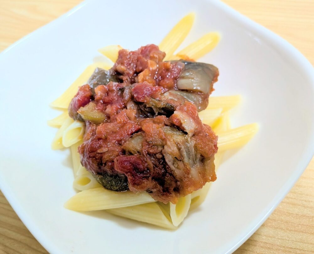 茄子とズッキーニのラタトゥイユのアレンジ料理写真。ペンネパスタをゆで、その上に赤く鮮やかなラタトゥイユをソースとしてかけたペンネパスタ。