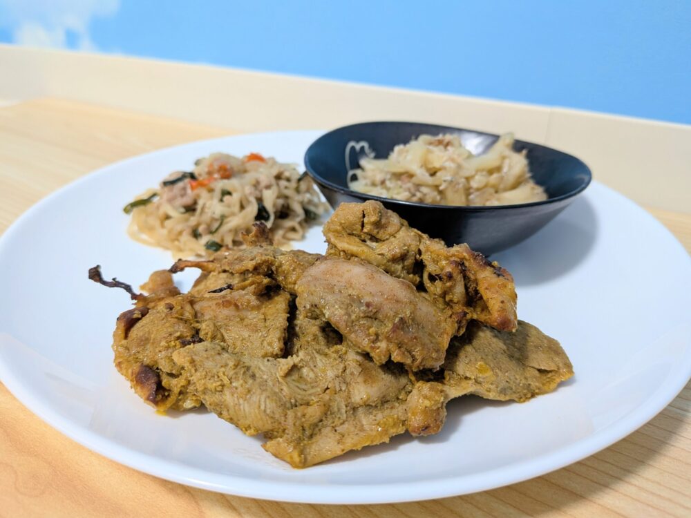 2日目のメニュー：タンドリーチキン、切干し大根とニラの中華炒め、キャベツのおかかあえが、白いお皿にのっている。タンドリーチキンはスパイスたっぷりの色合い。